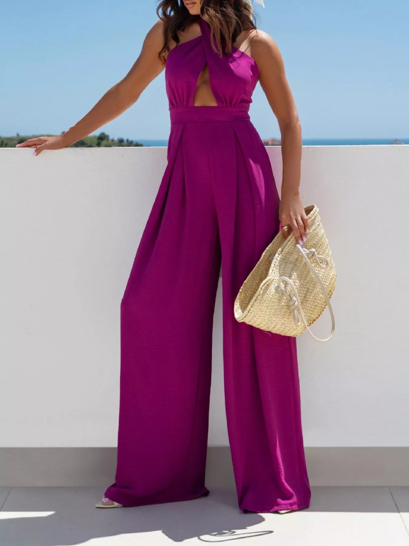 Women's halter-neck jumpsuit with cutout detailing, ties, and wide legs.