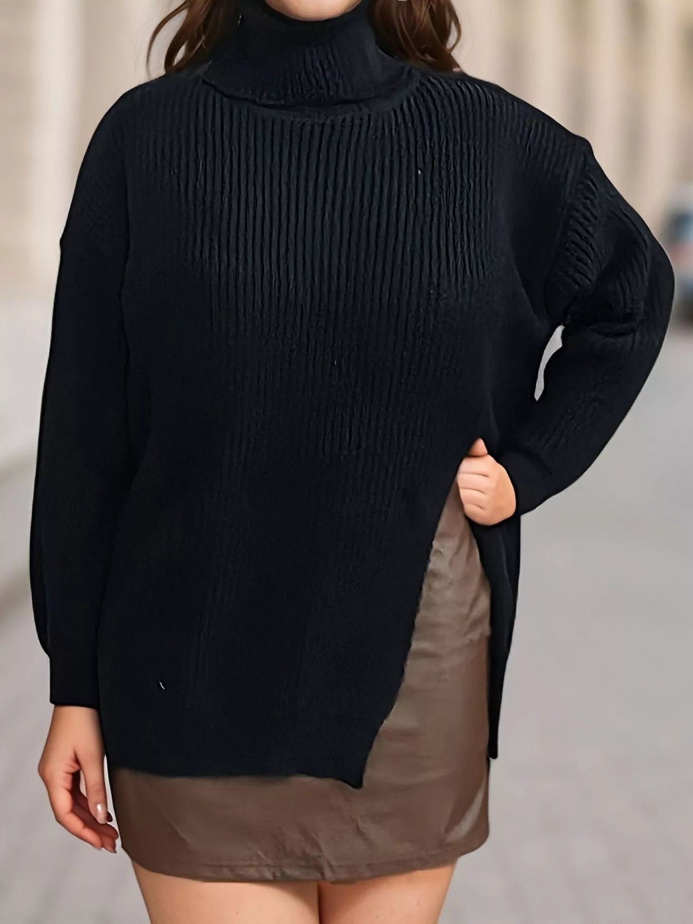 Front view of black ribbed turtleneck sweater with side slit