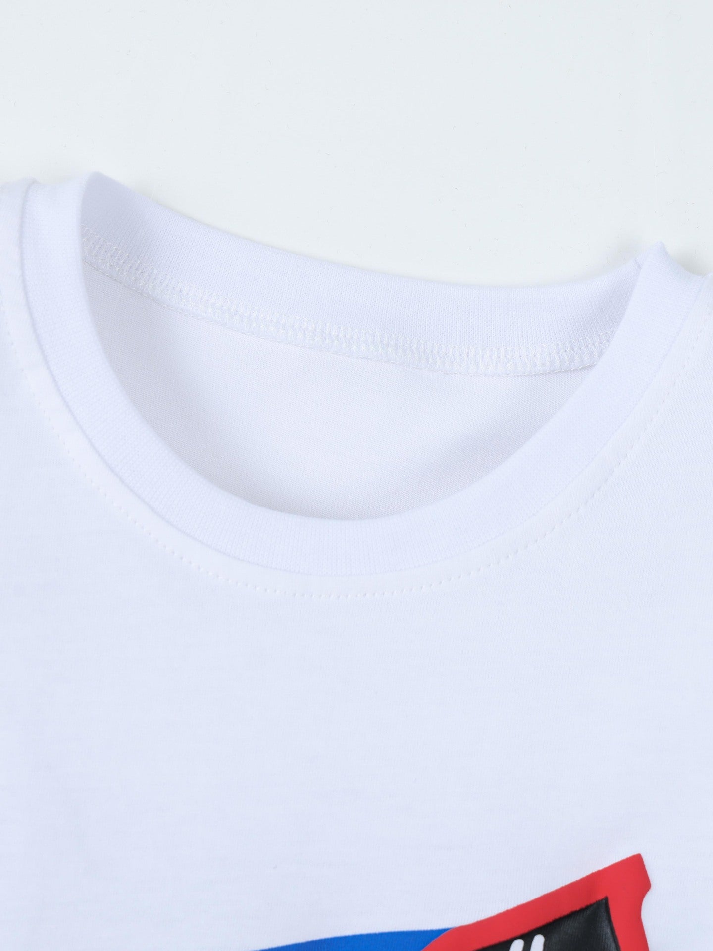 Close-up detail of the white round neckline and stitching on children's shark graphic T-shirt