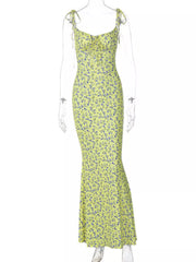 Clear mannequin displaying yellow floral print bodycon maxi dress with tie straps on white background