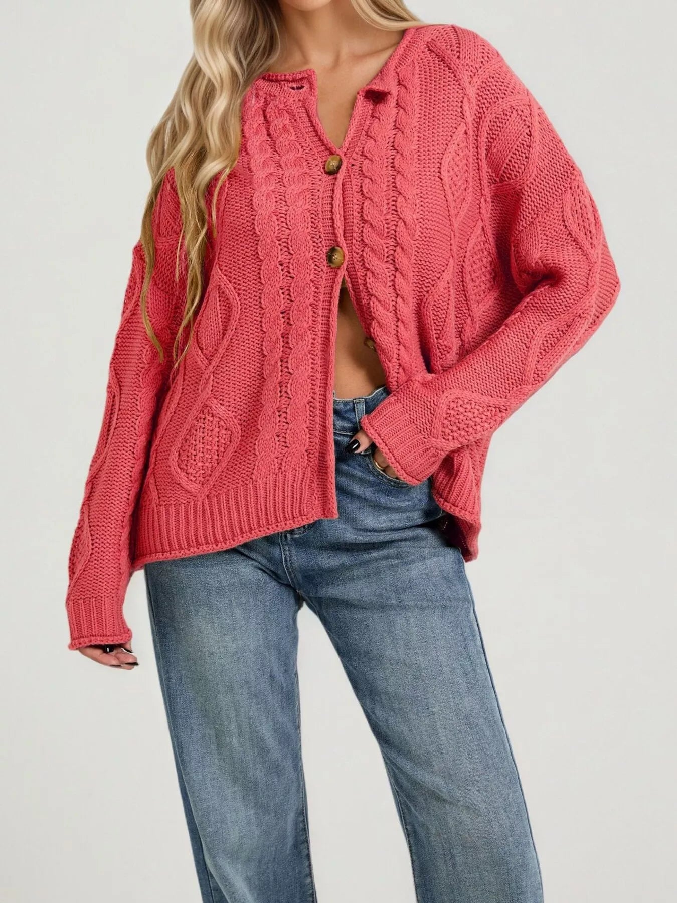 Front view of red cable knit button down cardigan with brown buttons and blue jeans