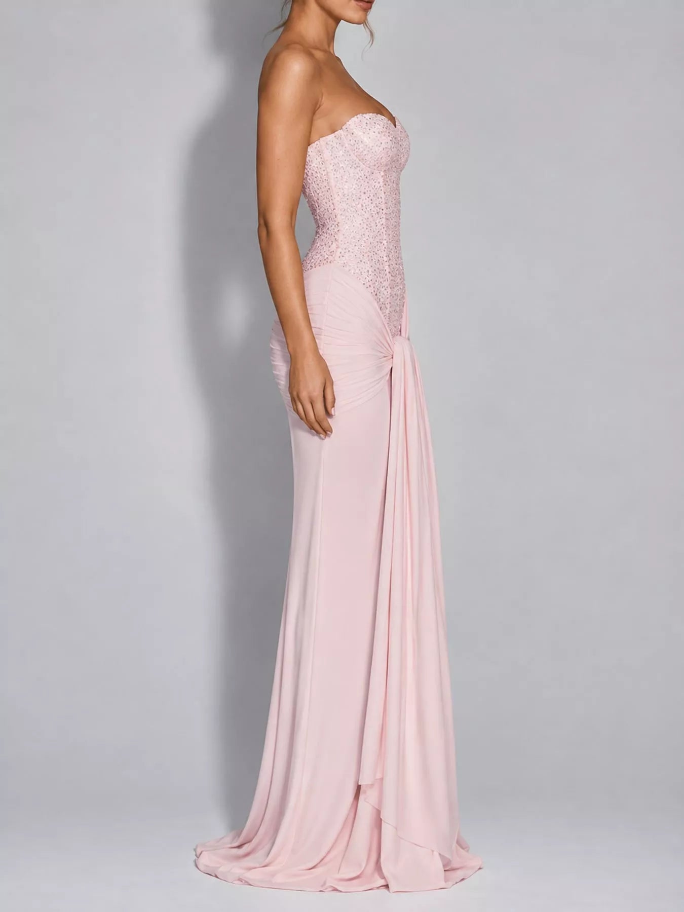 Pink strapless sequin corset maxi dress on model, full length side profile in studio