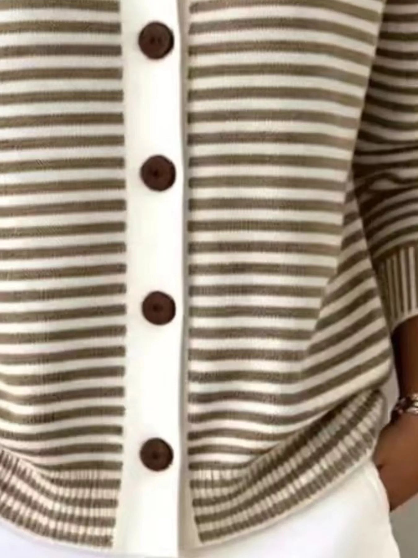 Close-up of the lower front and ribbed hem of a brown and white striped knit cardigan