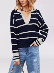 On-model front view of dark navy striped Johnny collar sweater holding a chain strap bag