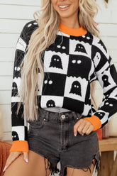 Front view of a black and white checkerboard sweater with ghost pattern and orange trim