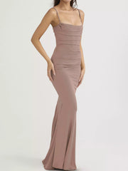 Side view of a dusty pink ruched spaghetti strap bodycon maxi dress in a studio