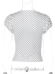 White polka dot top with short ruched sleeves and a V-neckline on a mannequin.
