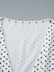 Close-up detail of the white polka dot top showing the ruched V-neckline and contrasting black dotted sleeves