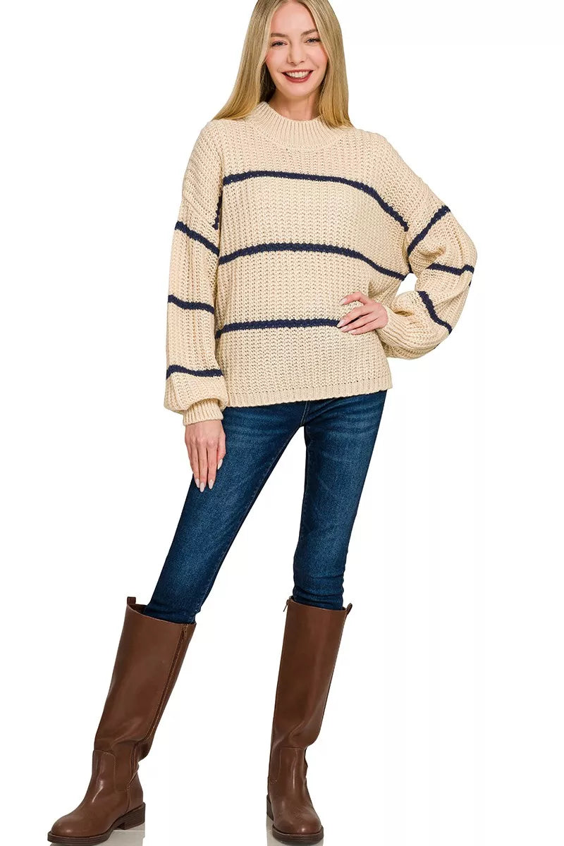 Full length view of cream oversize striped sweater with jeans and brown boots