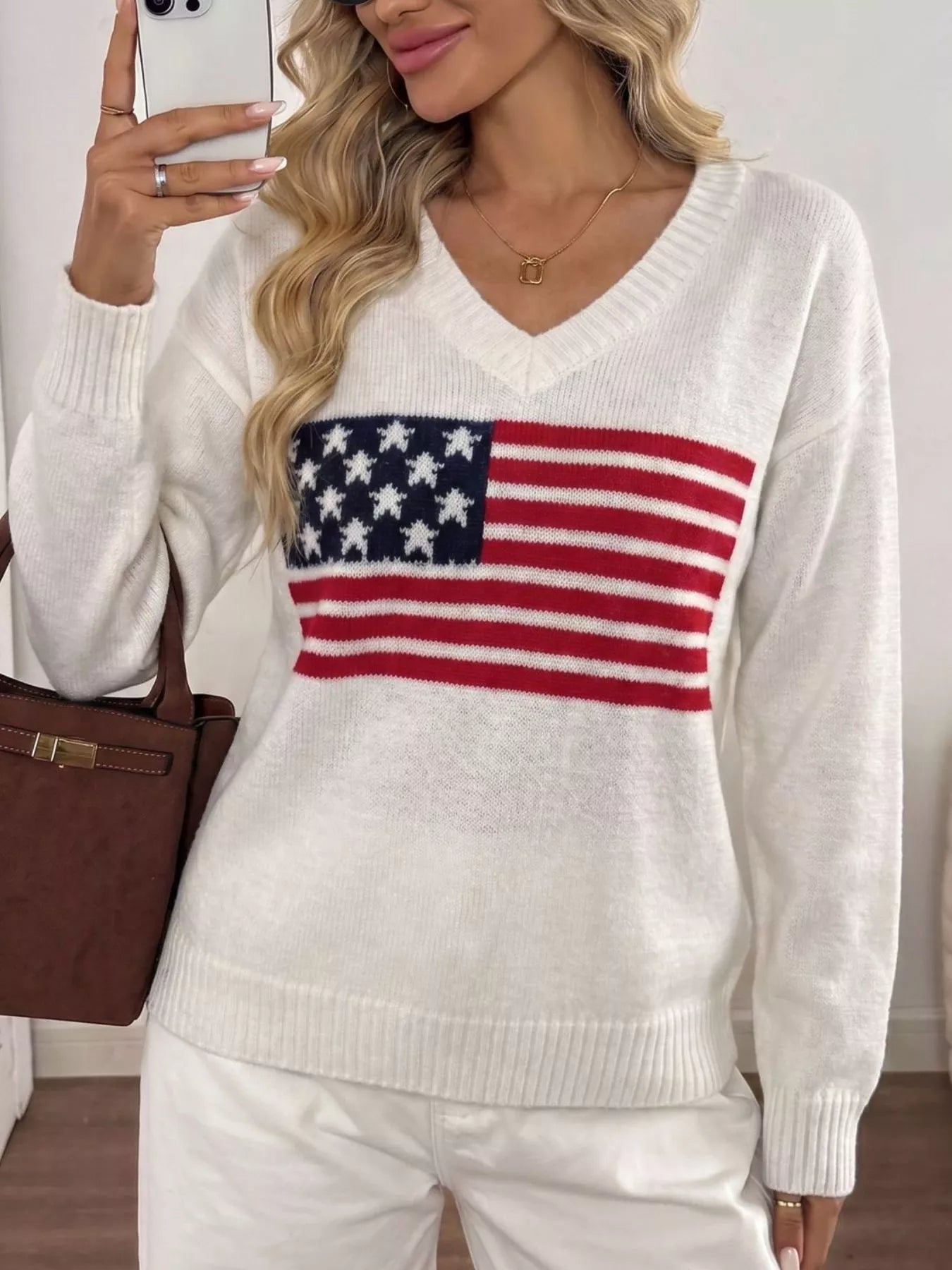 Mirror front view of white V neck knit sweater with American flag stars and stripes print.