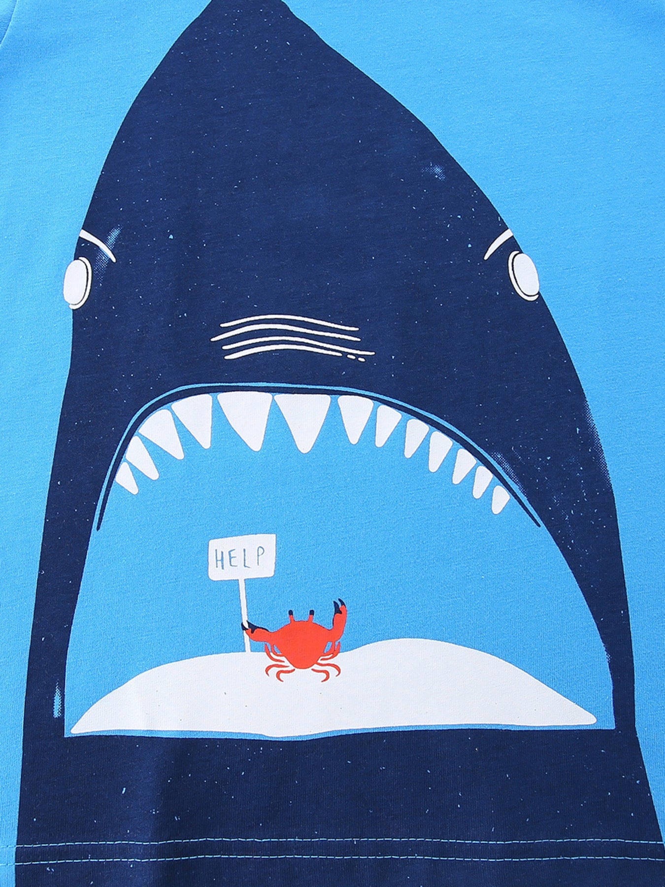 Close up of dark blue shark mouth print with small red crab on sky blue children's t-shirt