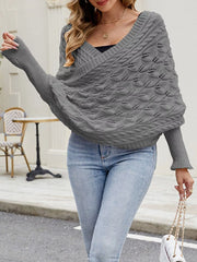 Front view of gray batwing sweater with V neckline, walking with arm raised.