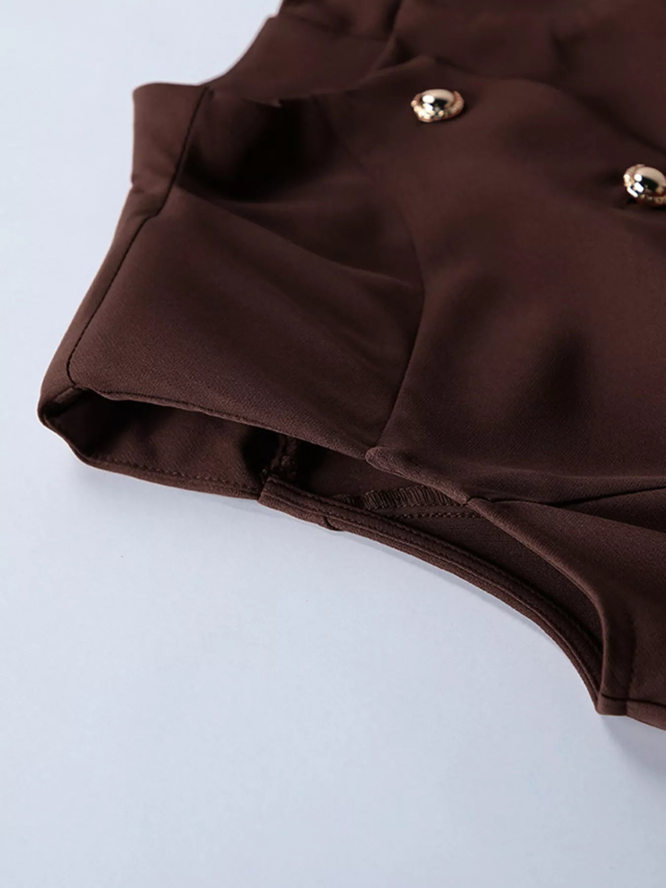 Brown button down mini dress detail showing shoulder seam and gold buttons flat