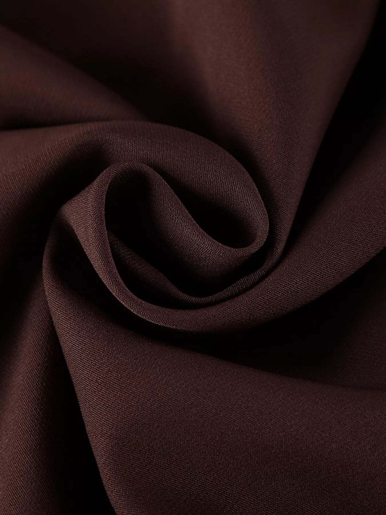 Close detail of brown button down mini dress fabric folded to show smooth texture