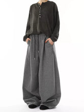 Men's gray wide-leg pants with a drawstring waist and pockets.
