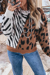 On-model mirror selfie of a fuzzy sweater split between black zebra stripes and brown leopard print