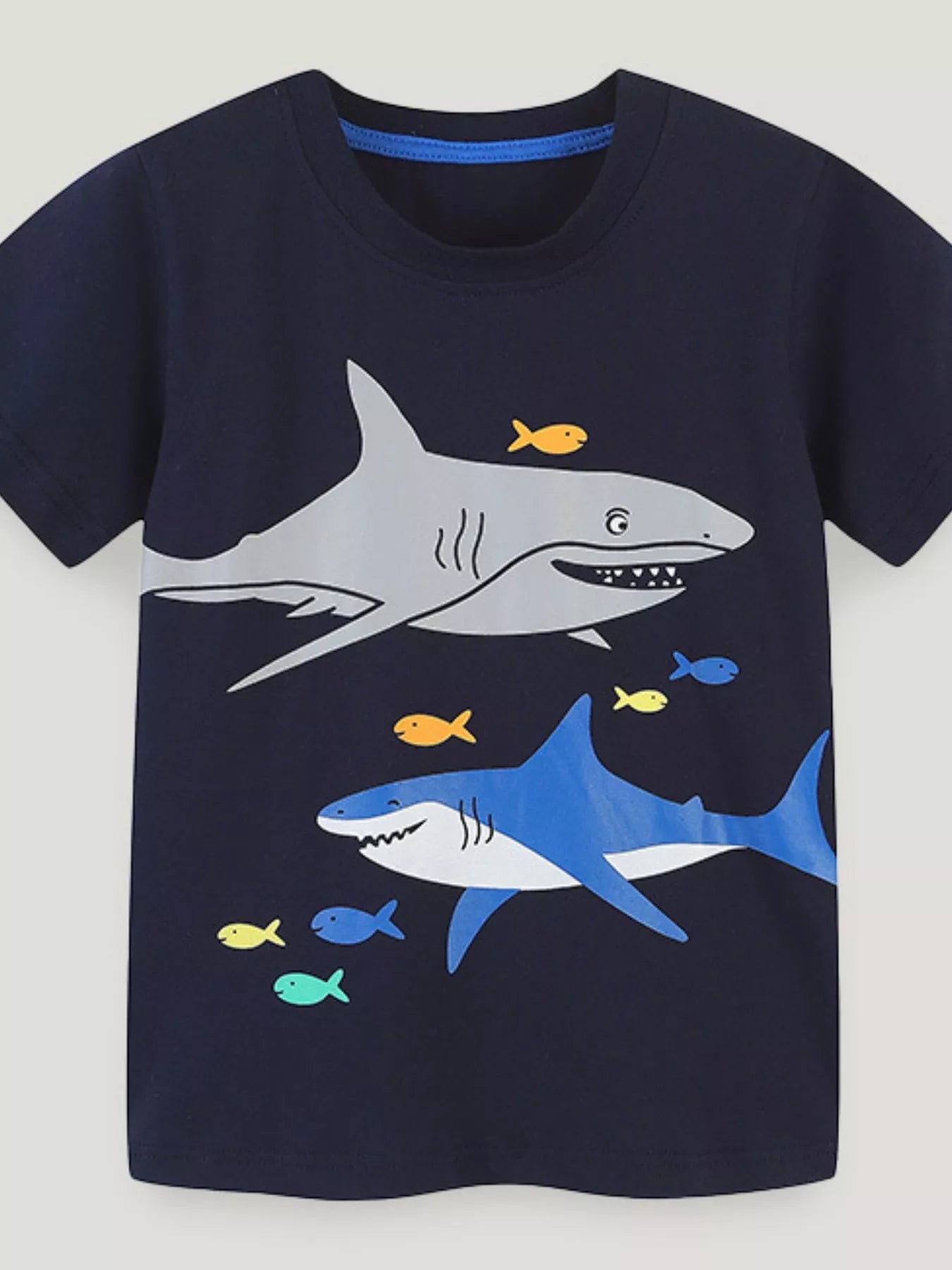 Front view of the black children's short sleeve t-shirt with gray and blue shark prints and small colorful fish