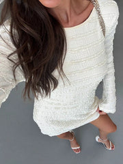 Close overhead view of pale apricot textured flare sleeve bodycon mini dress bodice and skirt