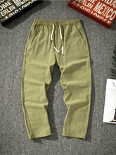 Men's army green loose-fit pants with a drawstring waist and pockets.