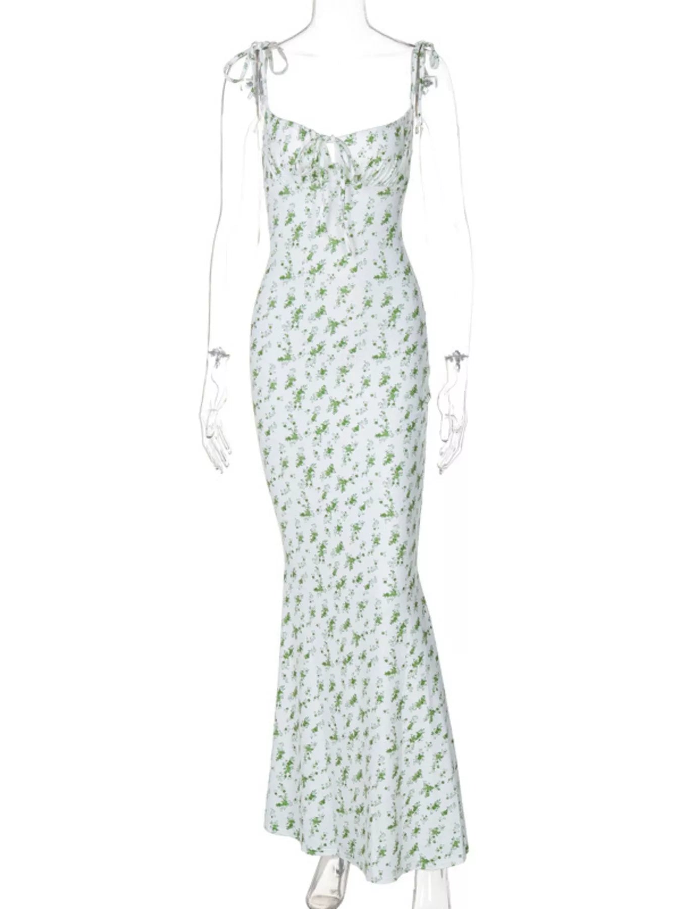 Clear mannequin displaying white and green floral print bodycon maxi dress with tie straps on white background