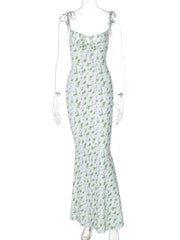 Clear mannequin displaying white and green floral print bodycon maxi dress with tie straps on white background