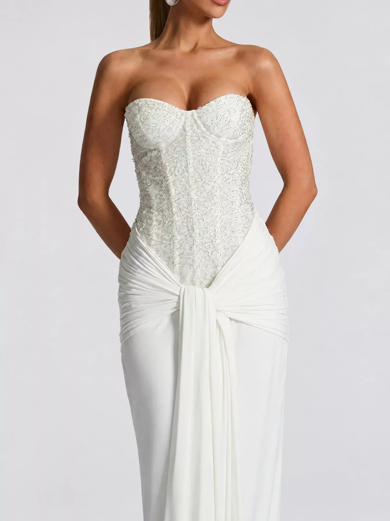 White strapless sequin corset bodice and draped waist detail, close front view on model