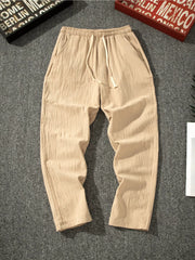 Men's khaki loose-fit pants with a drawstring waist and pockets.