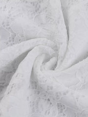 Close up fabric detail of a white lace maxi dress showing the floral lace texture