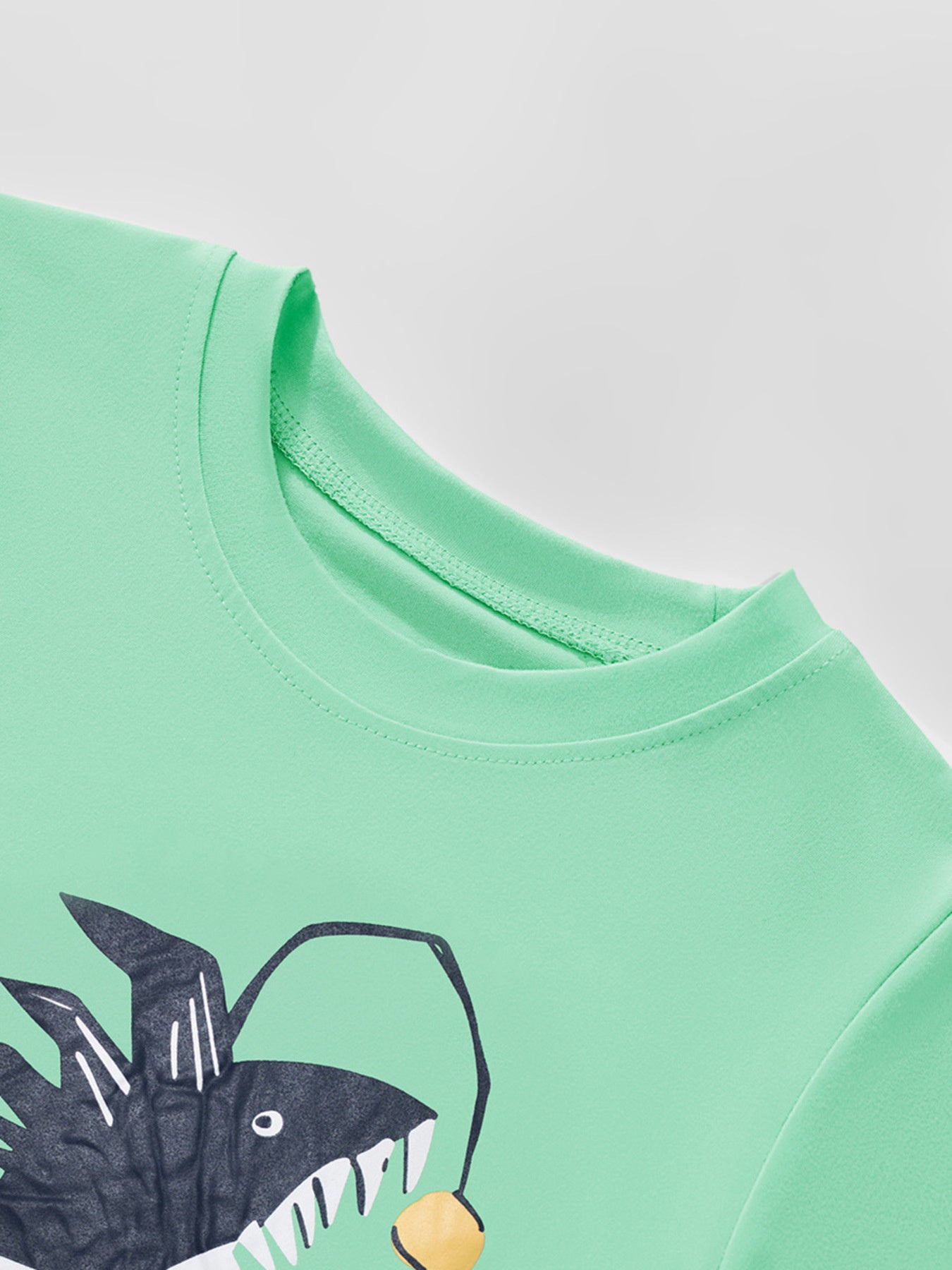 Close-up of the round neckline and stitching on the children's neon green t-shirt