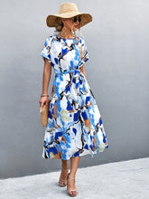 Women's blue A-line midi dress with a round neckline, short sleeves and tie waist.
