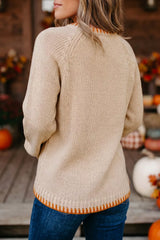 Back view of a beige long sleeve sweater with orange hem trim, shown outdoors