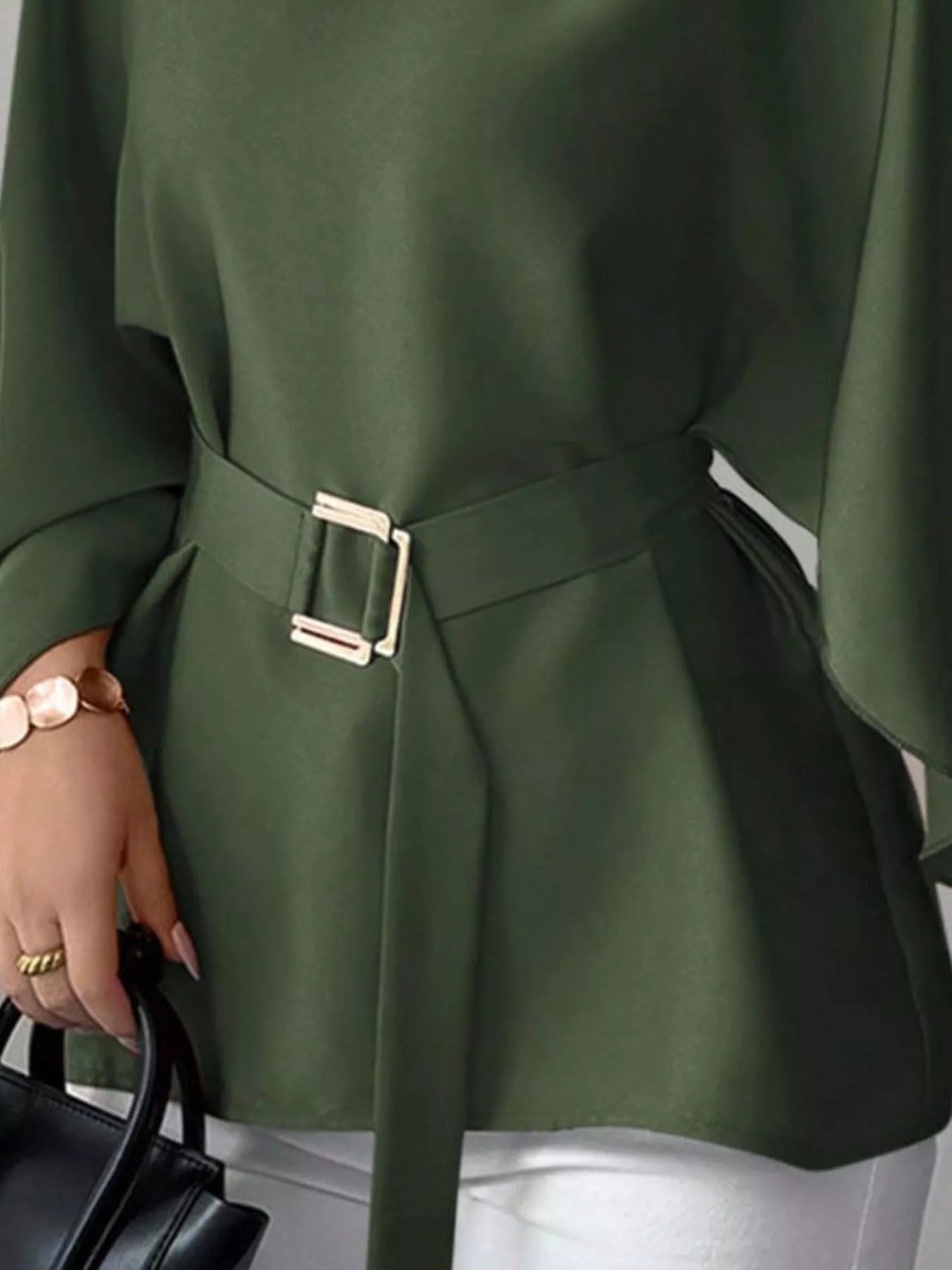 Close detail of army green batwing sleeve blouse gold buckle belt and flared hem