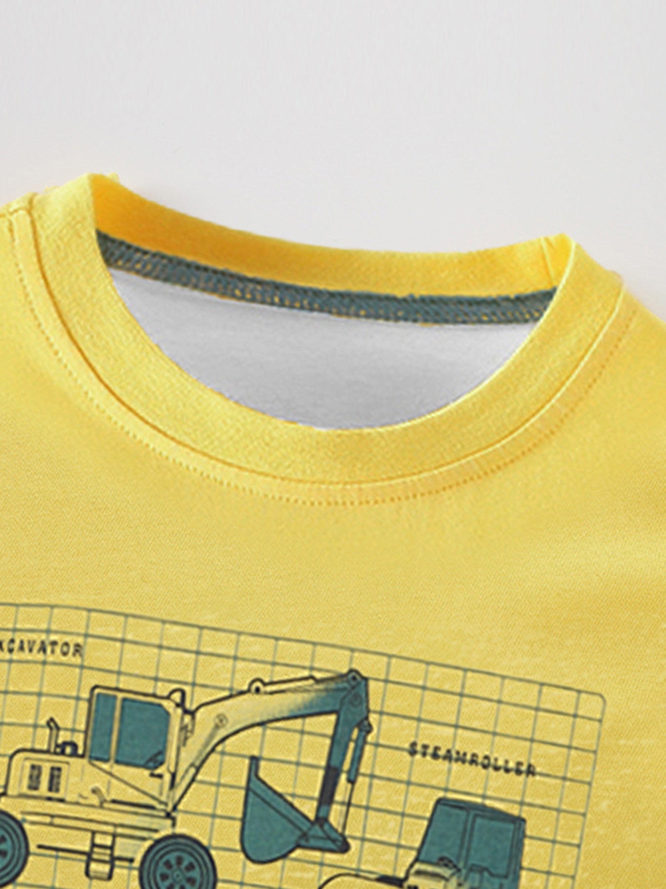 Close-up of the yellow children's t-shirt neckline and the top of the excavator graphic