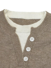 Close up of khaki sweater neckline with white layered top and white buttons
