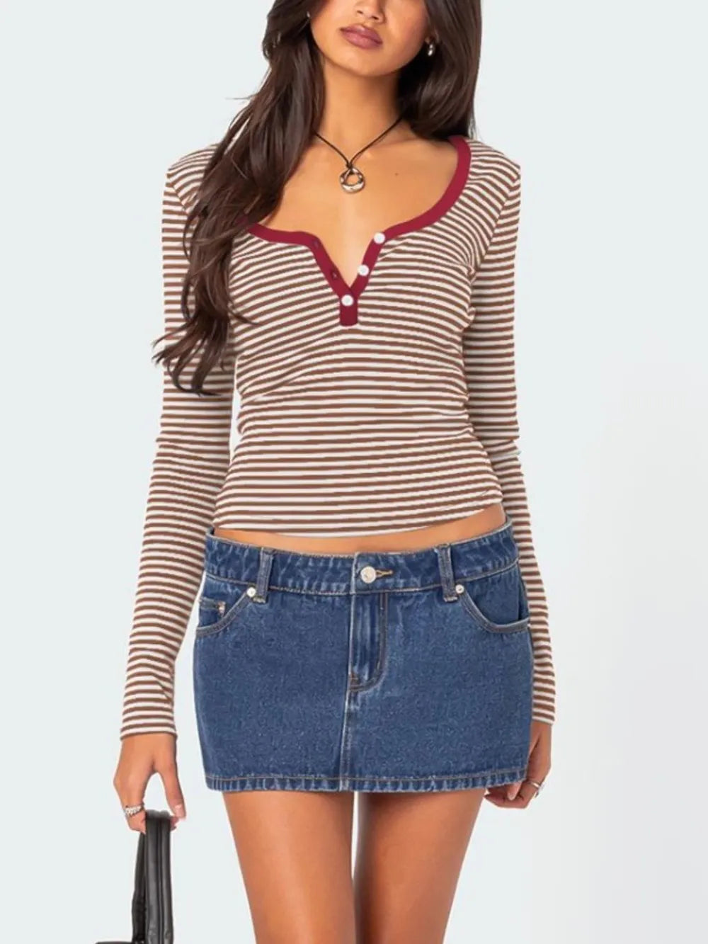 Front view of brown and white striped long sleeve t shirt with deep red trim worn with denim skirt