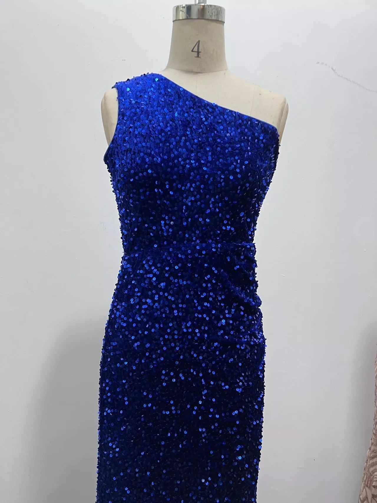 Royal blue sequin one shoulder evening dress shown front facing on a dress form
