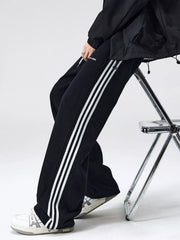 Men's black relaxed-fit pants with side stripes, a drawstring waist and pockets.
