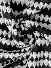 Extreme close-up of the black and white striped knit texture of the sweater dress fabric