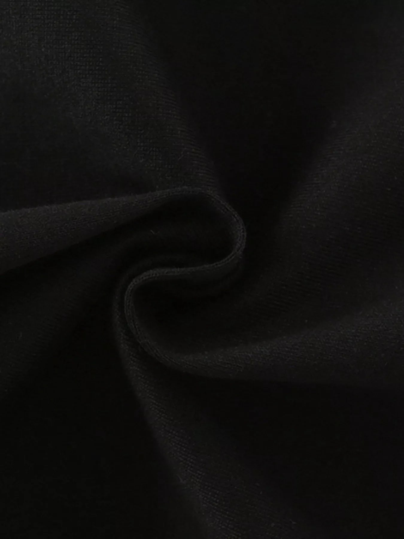 Close view of the soft twisted black knit fabric texture of the children's T-shirt
