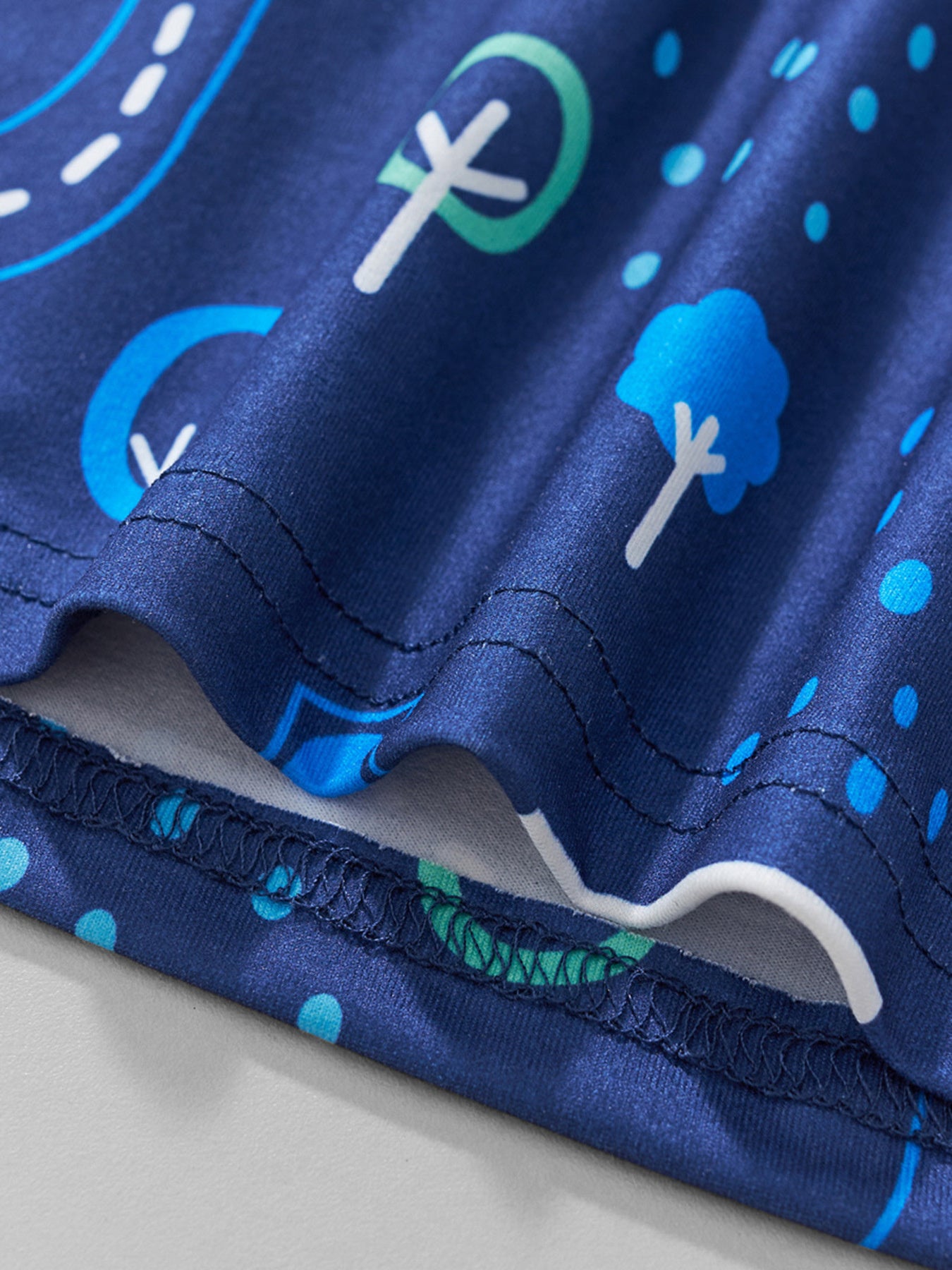 Close-up of the hem stitching and fabric texture on the children's dark blue tee