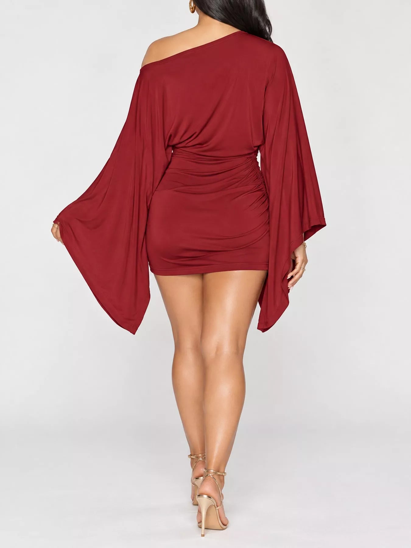 Back studio view of red one shoulder draped bodycon mini dress with wide sleeves