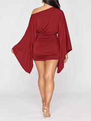 Back studio view of red one shoulder draped bodycon mini dress with wide sleeves