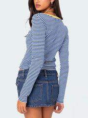 Back view of royal blue and white striped long sleeve t shirt with pale yellow neckline trim worn on model