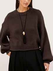 Close on-model front view of a brown oversized chunky knit sweater with ribbed hem
