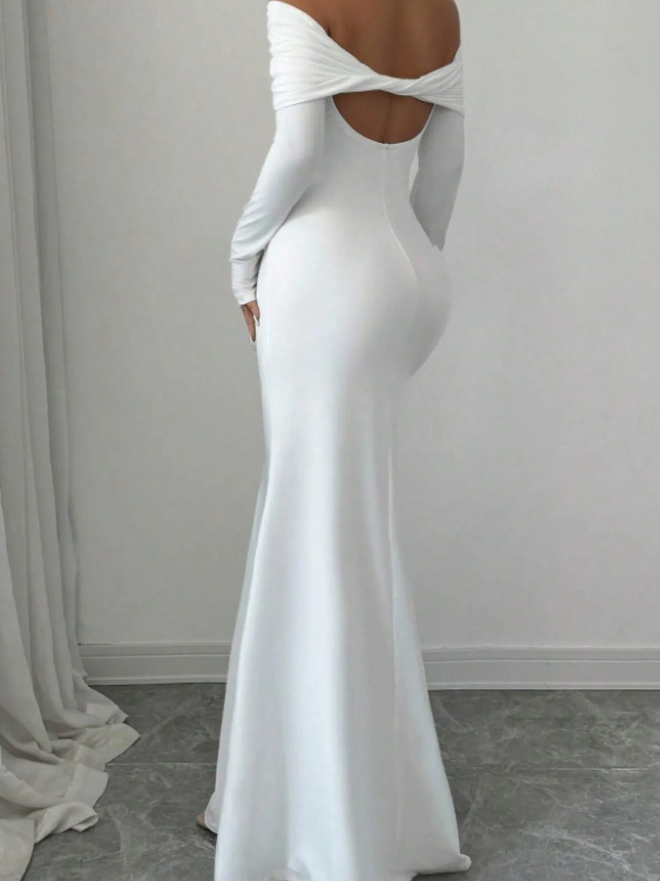 Back full view of white off shoulder bodycon maxi dress with twisted back cutout