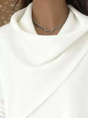 Close-up of the white cowl neckline showing the draped asymmetric collar and fine knit texture