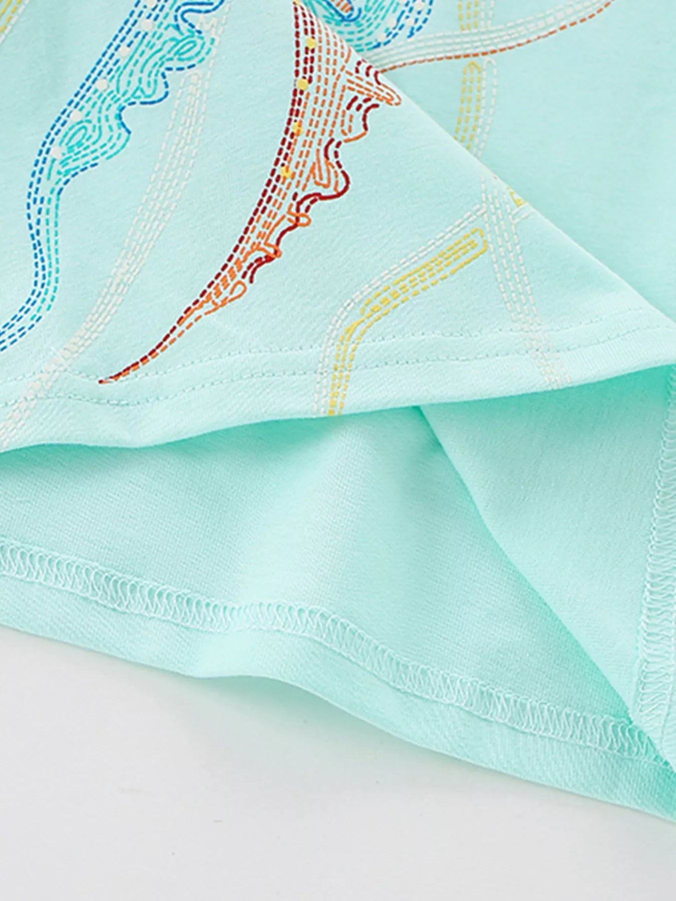 Close-up of jellyfish tentacles and hem stitching on mint blue children's t-shirt