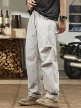 Men's light gray relaxed-fit casual pants with a drawstring waist and pockets.