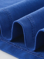 Close view of the stitched hem and folded fabric on an indigo children's t shirt