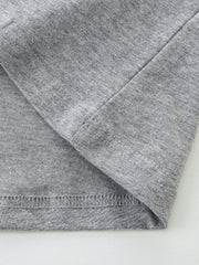 Close up of gray children's t-shirt hem and sleeve stitching with heathered fabric texture